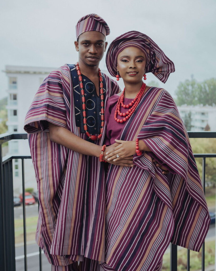 Couple smiling together on balcony with Aso-Oke outfit
